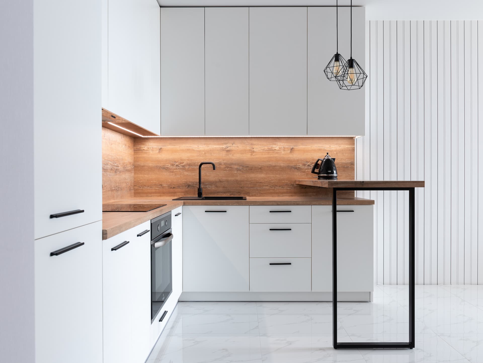 Cocina decorada con muebles en blanco y banco de trabajo de madera